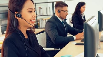Several people with headsets help their customers with support via telephone.